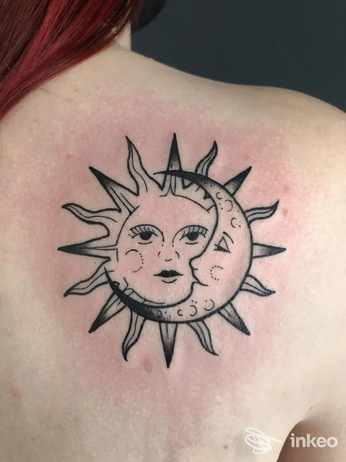 Tatuaggio nero a sole e luna sulla parte superiore della schiena, foto da Nebula Tattoo Studio a Borgo A Buggiano.