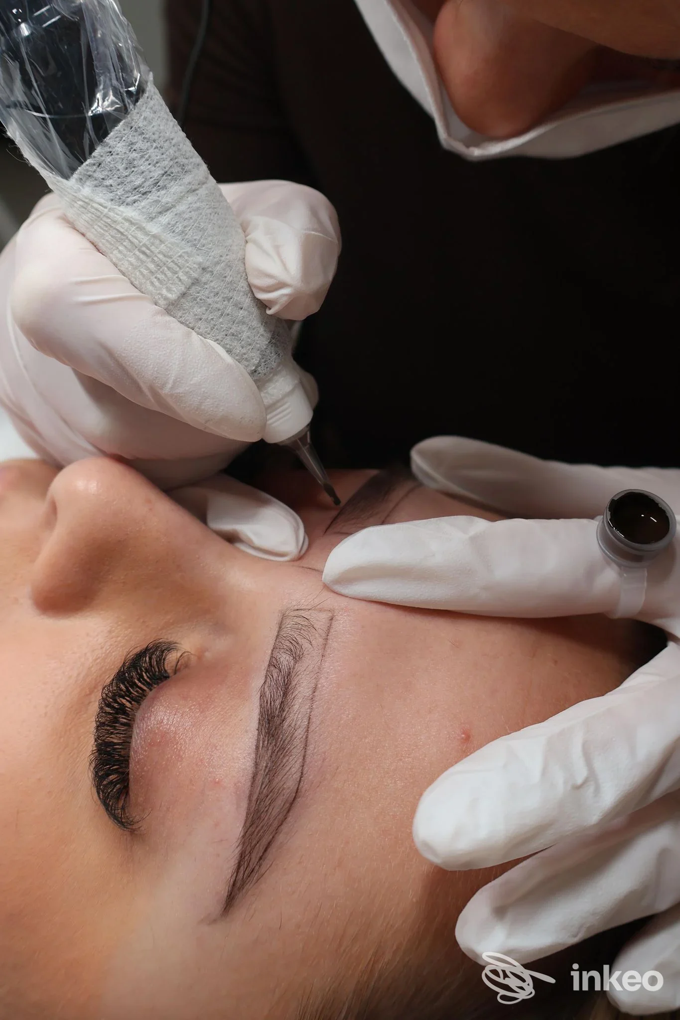 Operatrice esegue microblading sul sopracciglio di una cliente, Pure Beauty der Lisa Grünfelder, Rablà.