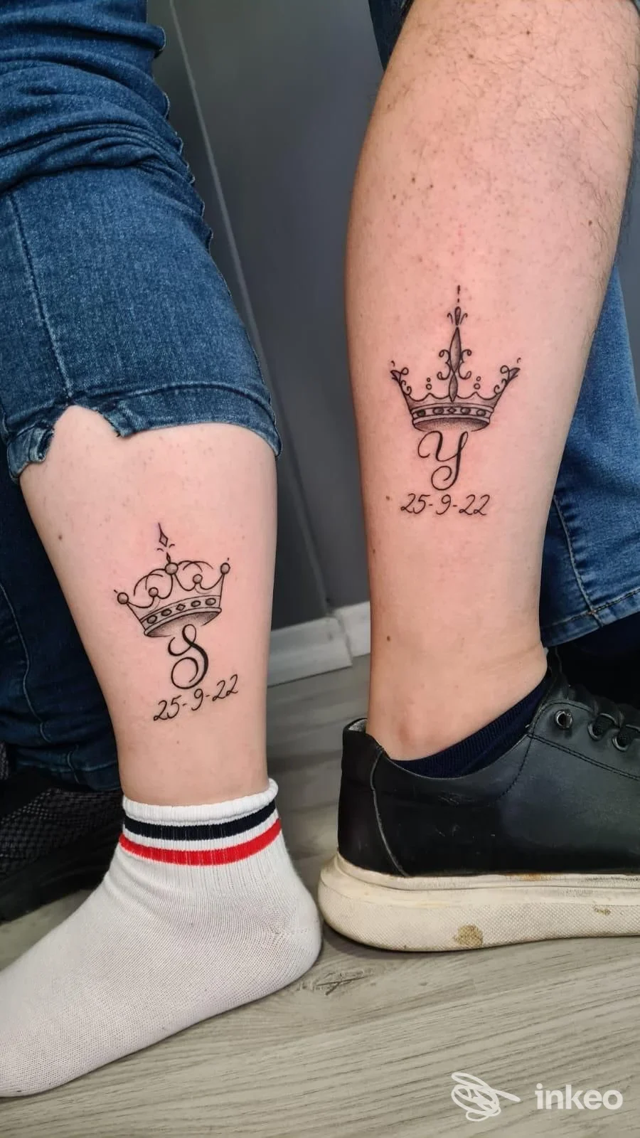 Due tatuaggi abbinati a Latina Scalo presso DEATH INK TATTOO STUDIO: corone nere con iniziali e data sui polpacci.