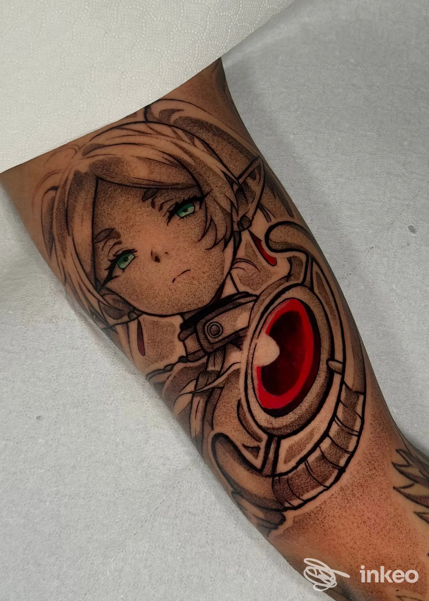 Tatuaggio su avambraccio di personaggio in stile anime con occhi verdi e dettagli meccanici, ampio riempimento rosso. DEATH INK TATTOO STUDIO, Latina Scalo.
