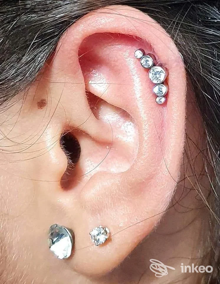 Piercing multipli all'orecchio con cluster di zirconi e due orecchini al lobo, foto inviata da Microbeauty Tattoo, Portella di Mare.