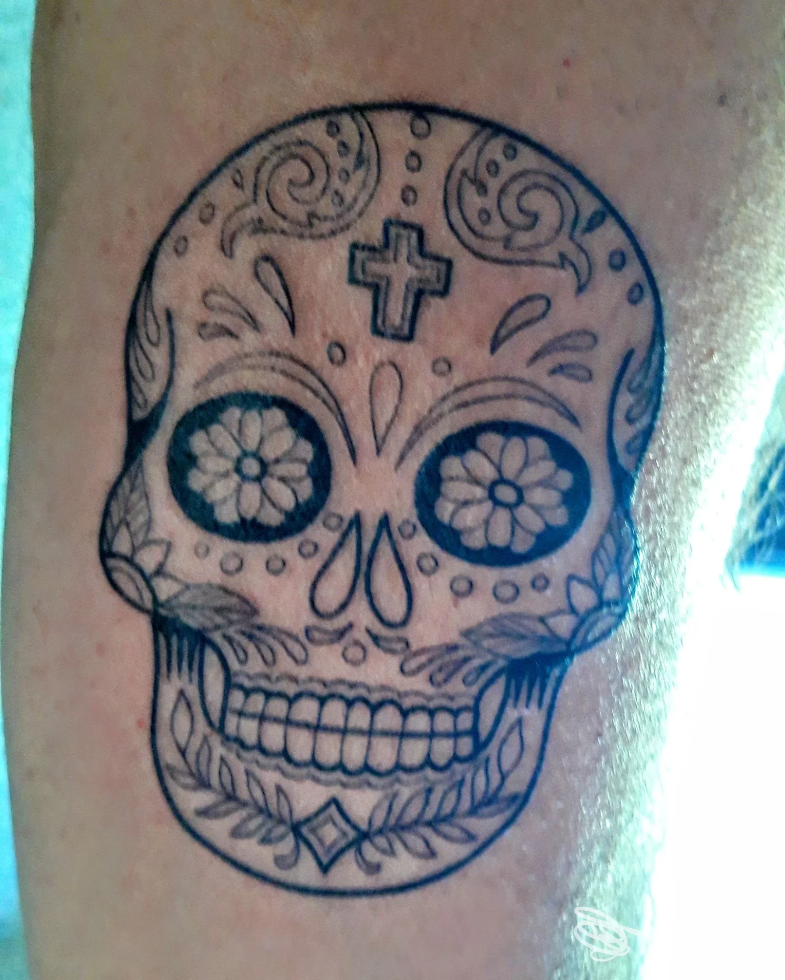 Tatuaggio a forma di teschio decorato realizzato da Tinta Loca Tattoo Studio a San Piero a Sieve sulla pelle del cliente.