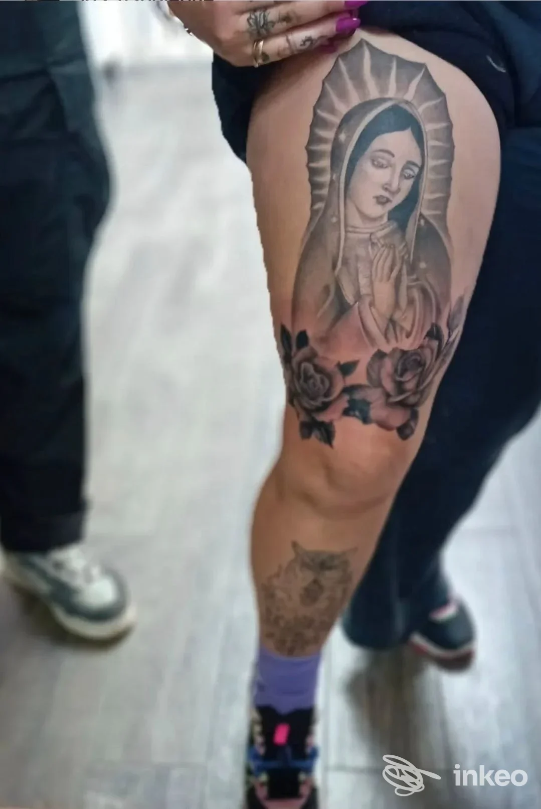 Tatuaggio in bianco e nero raffigurante una Madonna con rose sull'esterno della coscia, foto inviata da tattoo store, Napoli.
