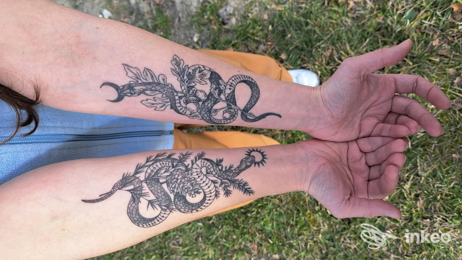 Due avambracci con tatuaggi neri a tema serpente e motivi vegetali, foto di Athanor Tattoo Studio, Verona.