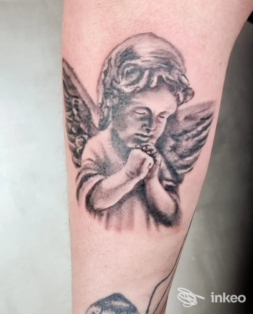Tatuaggio in bianco e nero di un angelo in preghiera sull'avambraccio, foto inviata da Tardox Tattoo, Salerno.