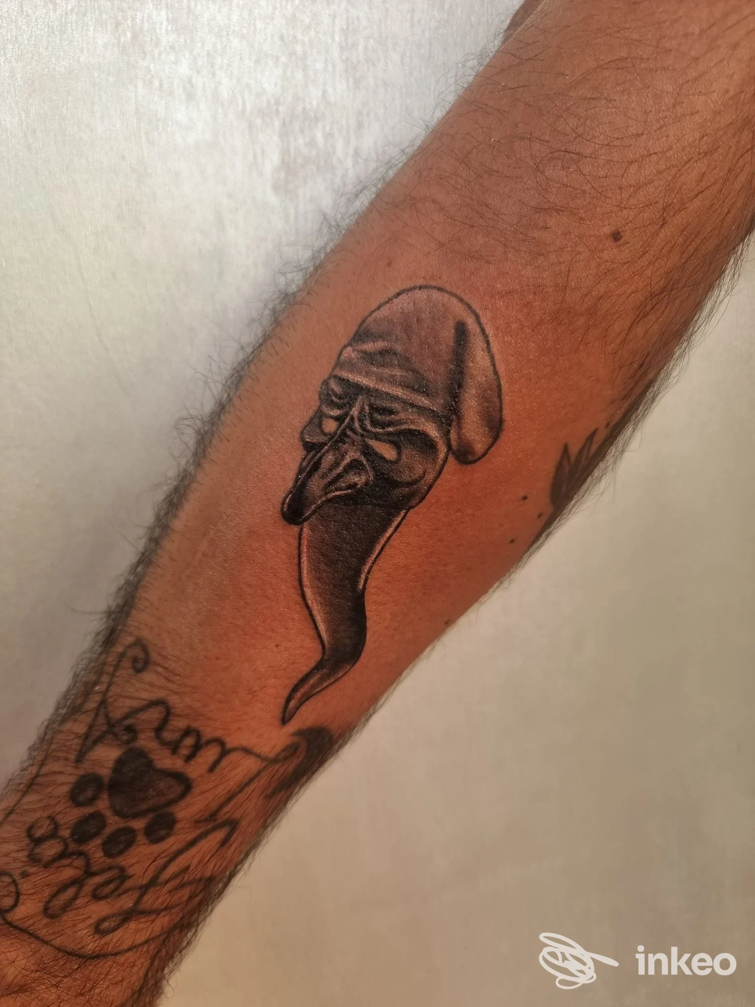 Tatuaggio nero/grigio su avambraccio raffigurante una maschera stilizzata, realizzato da Tardox Tattoo a Salerno.