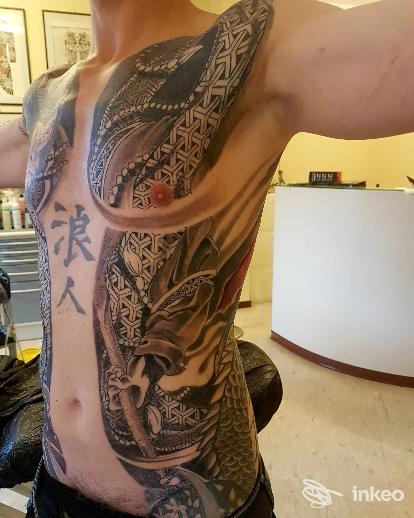 Torace e fianco tatuati con grande composizione a motivi intrecciati e koi, foto fornita da VENETIAN TATTOO ARTIST, Venezia.