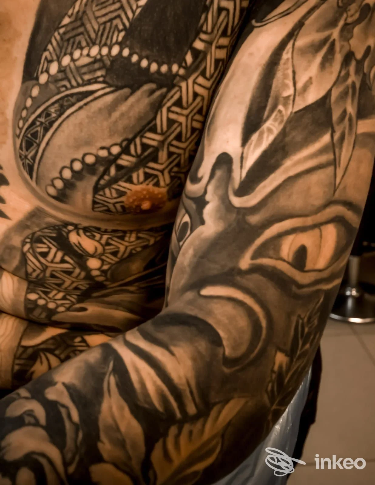 Foto ravvicinata di tatuaggi su braccio e petto, opera di VENETIAN TATTOO ARTIST a Venezia.