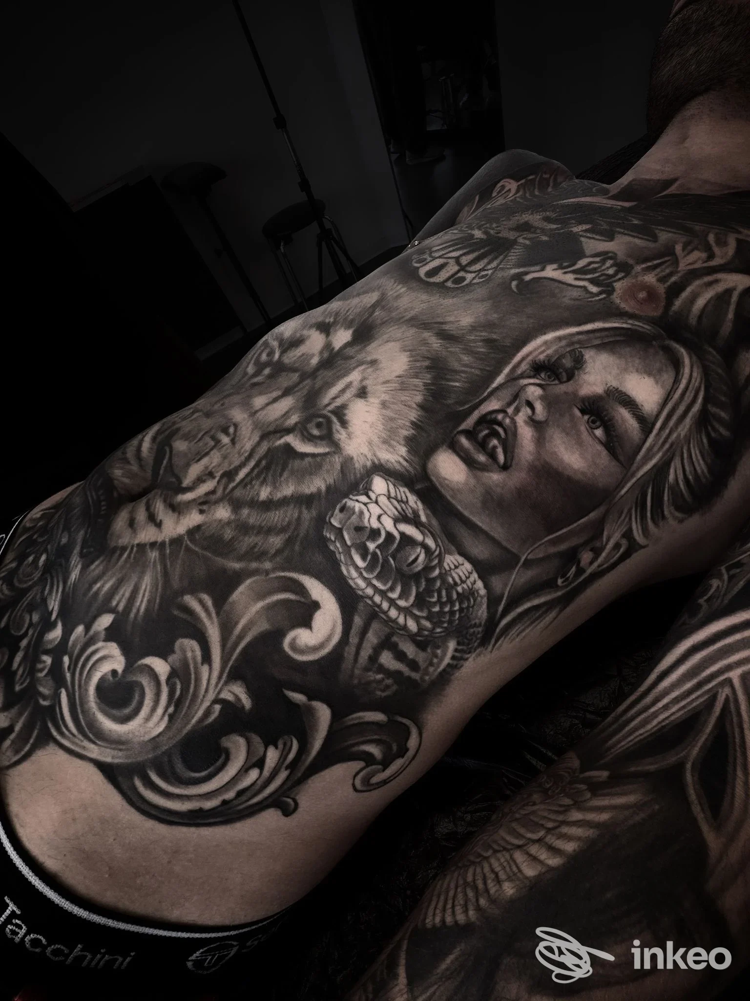 Tattoo su avambraccio sinistro raffigurante figura femminile, dettagli realistici in bianco e nero, con ornamenti floreali e sfumature.