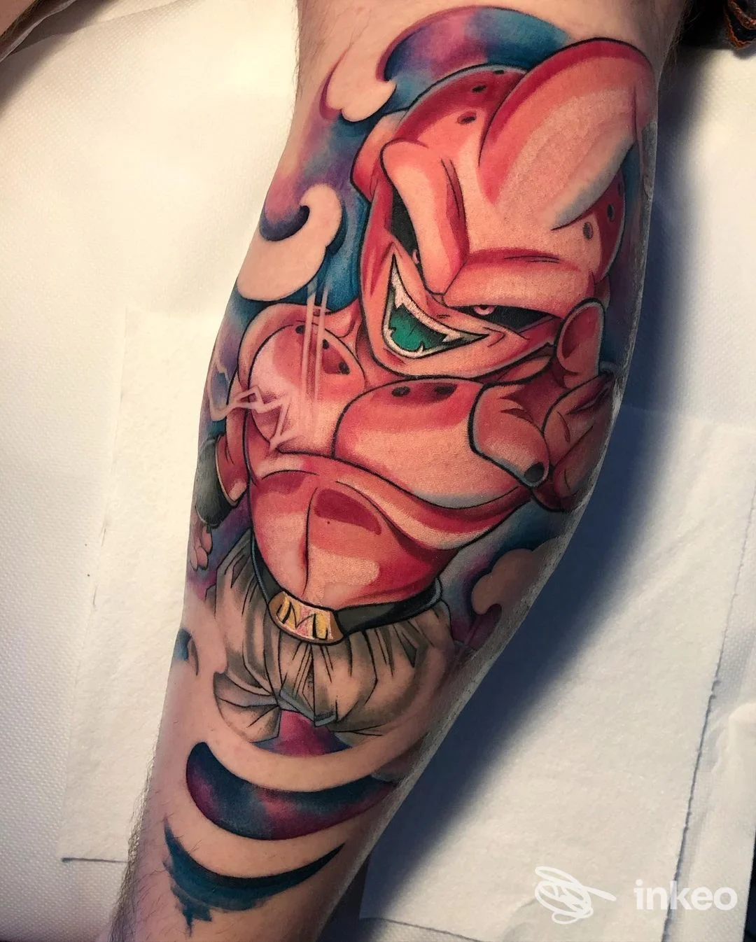 Tattoo colorato su avambraccio raffigurante personaggio fumettistico, con linee nette e sfumature rosse e rosa, su pelle nuda.