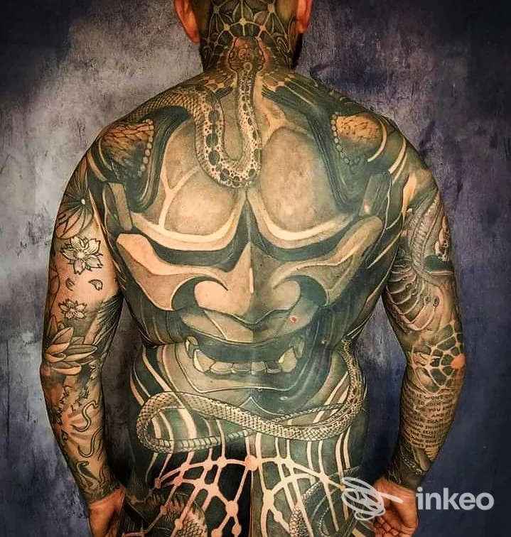 Schiena e braccia di un uomo completamente tatuate in stile noir/geomtrico, dettaglio di motivi intricati coprendo la pelle; scatto dall’indietro senza viso, su sfondo scuro. Studio Prime Soul Tattoo.