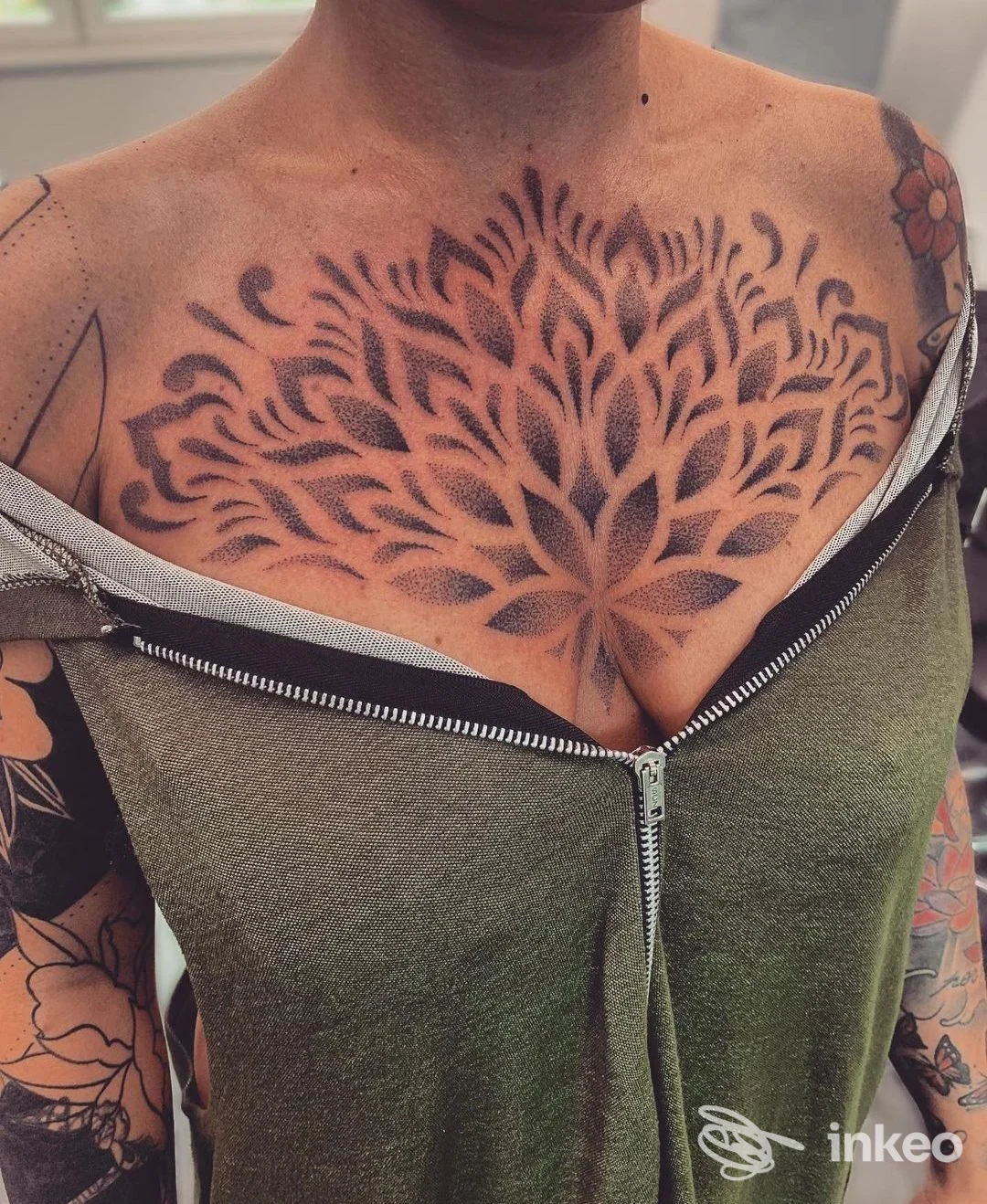 Tattoo grande sul torace di una persona, motivo floreale a corolla scuro che si estende dalle clavicole, senza volto visibile nell’inquadratura. Studio Tattoo Parlour.