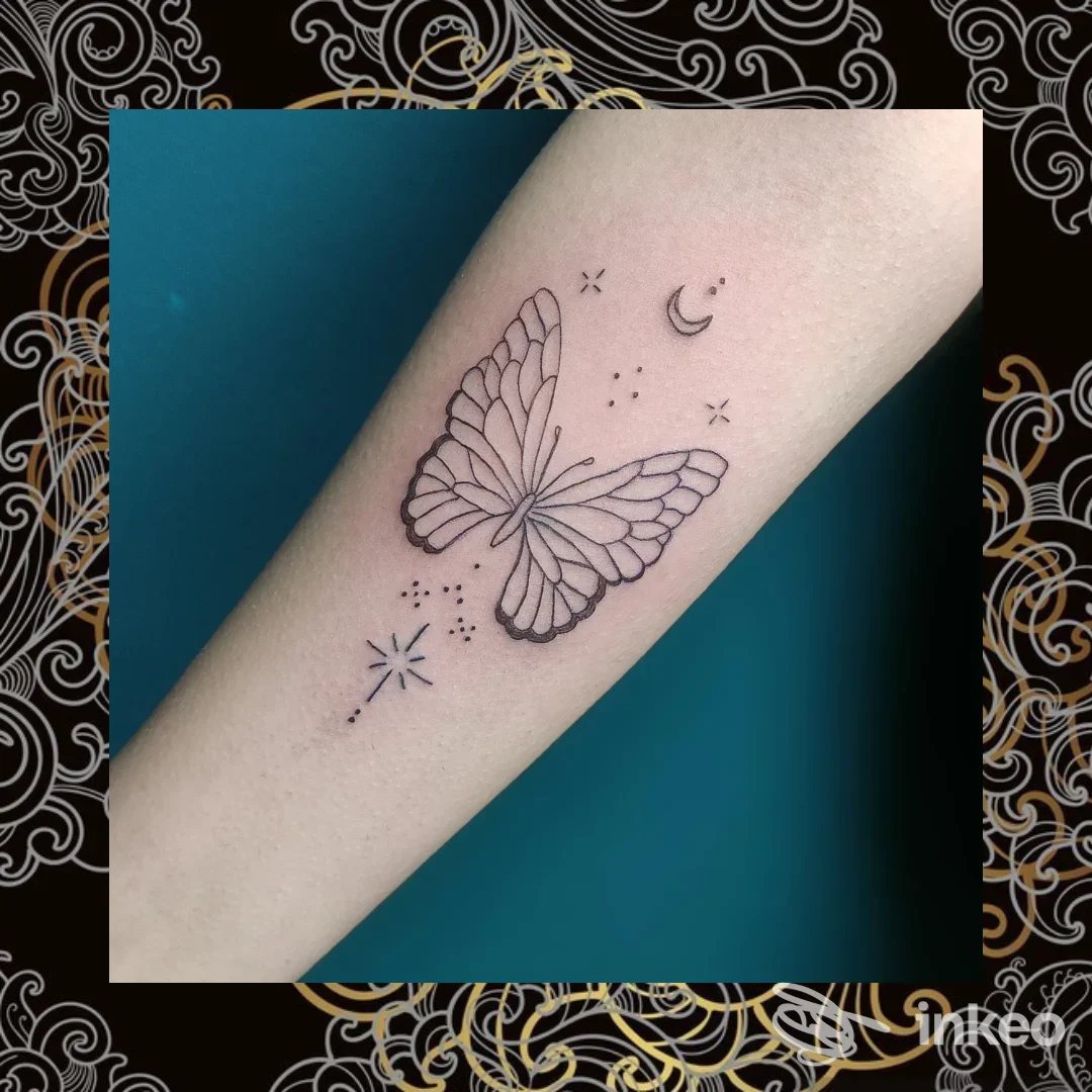 Tattoo su avambraccio con una farfalla e elementi stellari, eseguito direttamente sulla pelle.