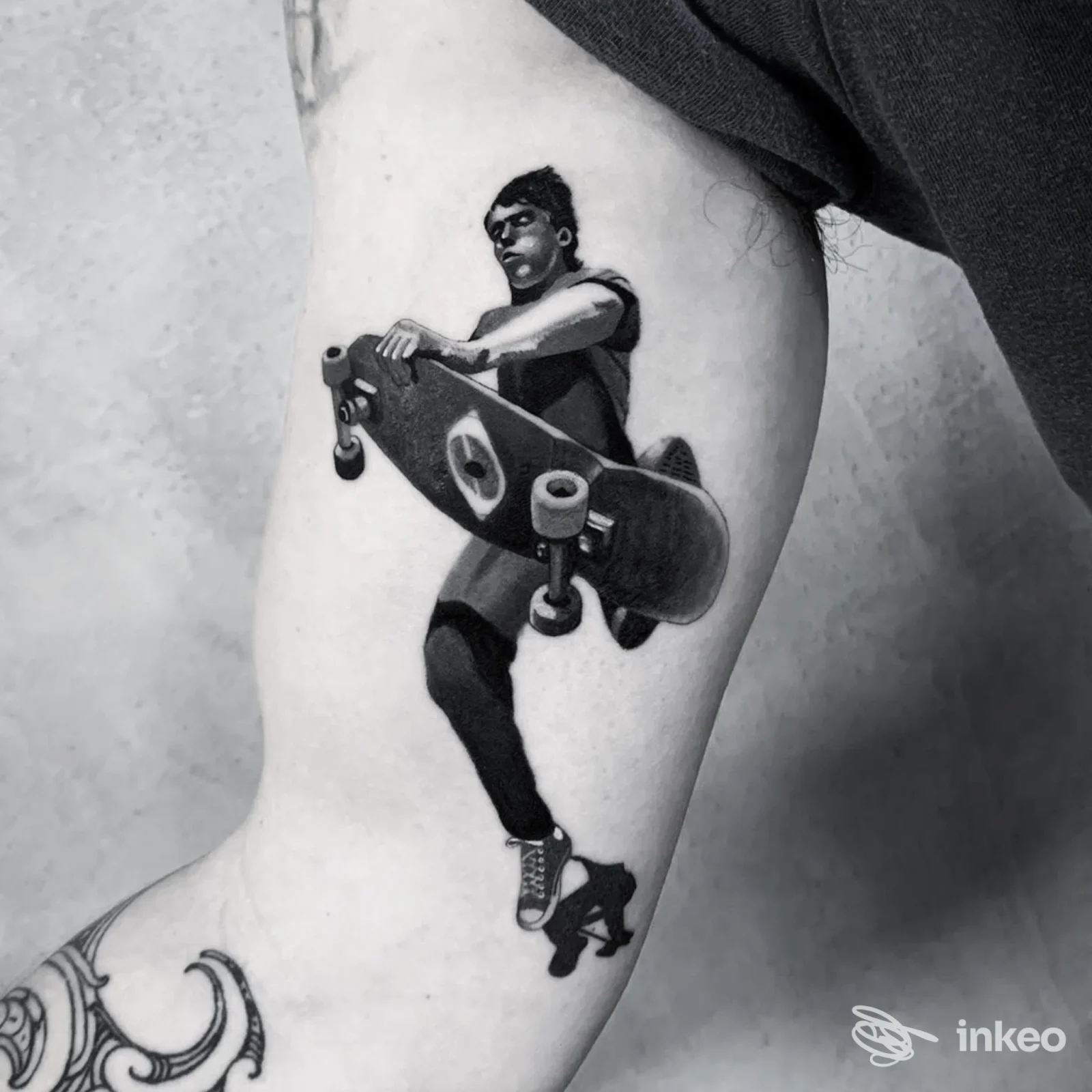 Tattoo realistico su pelle di un braccio: figura di skateboarder in atteggiamento dinamico, tatuaggio ben definito su braccio sinistro, senza testo o overlay visivi. The Good Choice Tattoo Parlor, città non specificata.