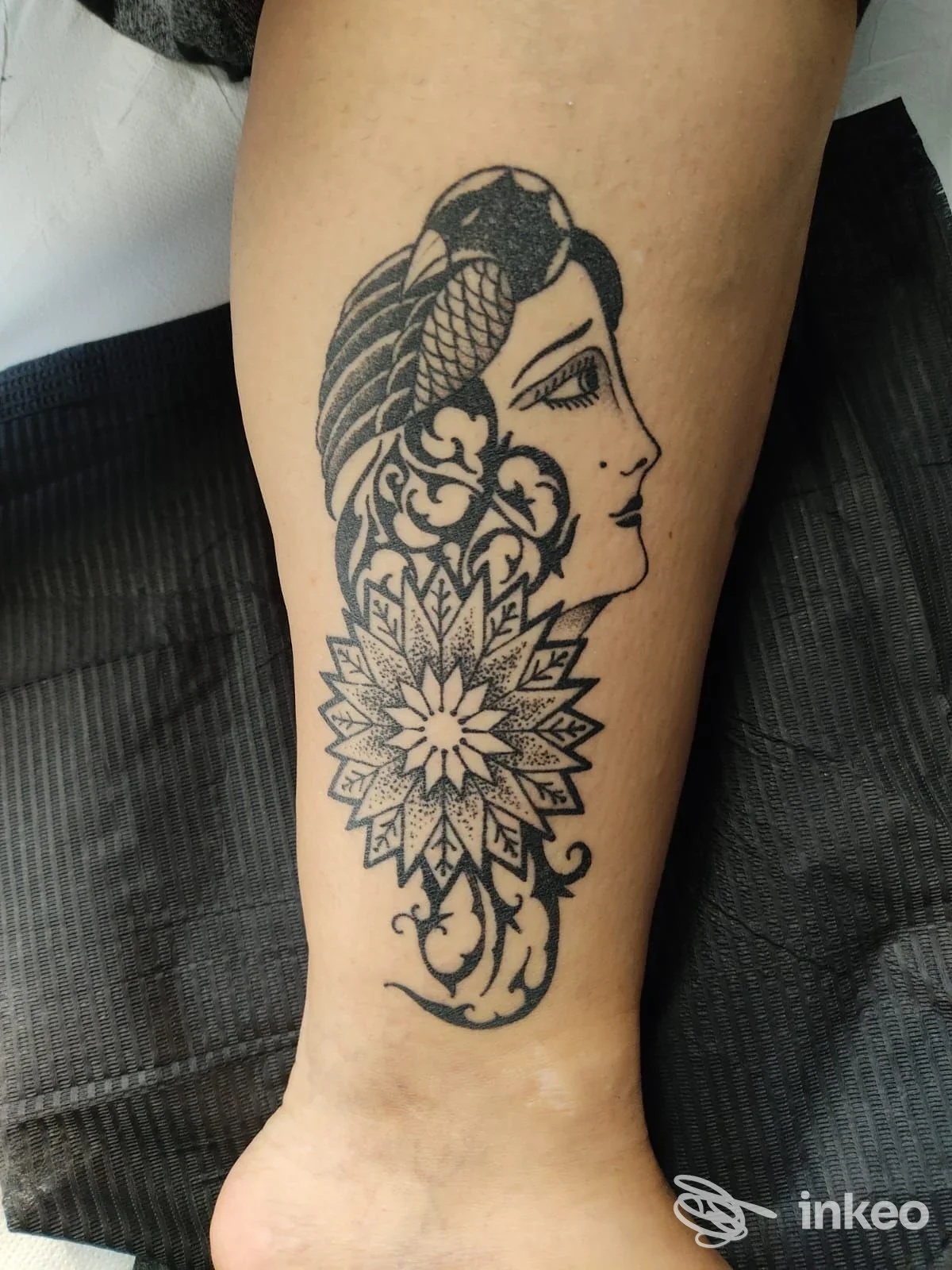 Tattoo visibile sull'avambraccio raffigurante profilo femminile e motivo mandala, senza testo o interfacce sociali