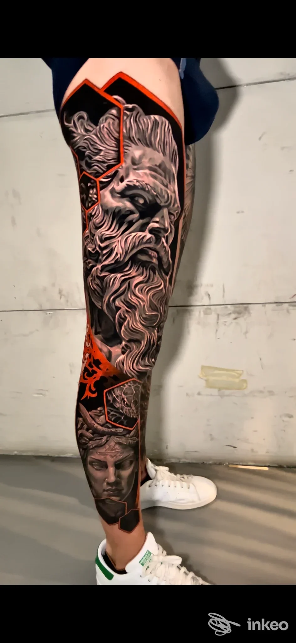 tattuale tattoo realistico in bianco e nero su gamba sinistra, polpaccio e parte superiore della caviglia, con dettagli molto definiti e bordi arancioni.