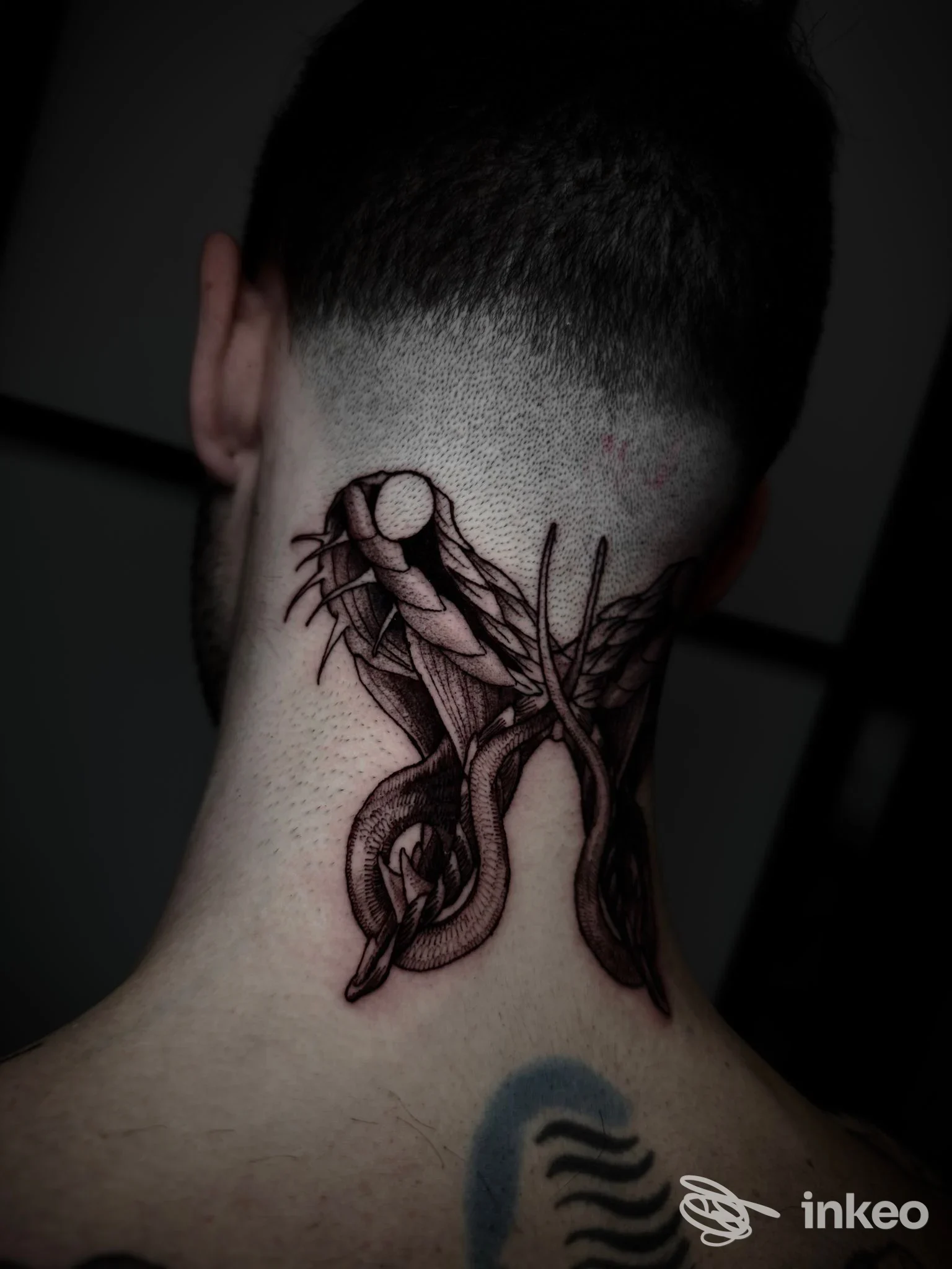 Tattoo sul collo posteriore raffigurante mani intrecciate in stile linework scuro, veduta laterale della nuca. non si distingue alcun volto intero.