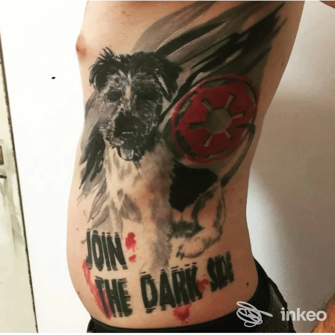 Tattoo visibile sul fianco sinistro di una persona: ritratto in bianco e nero di un cane con grafica rossa a forma di cerchio e testo “JOIN THE DARK SIDE” lungo la parte bassa del fianco.