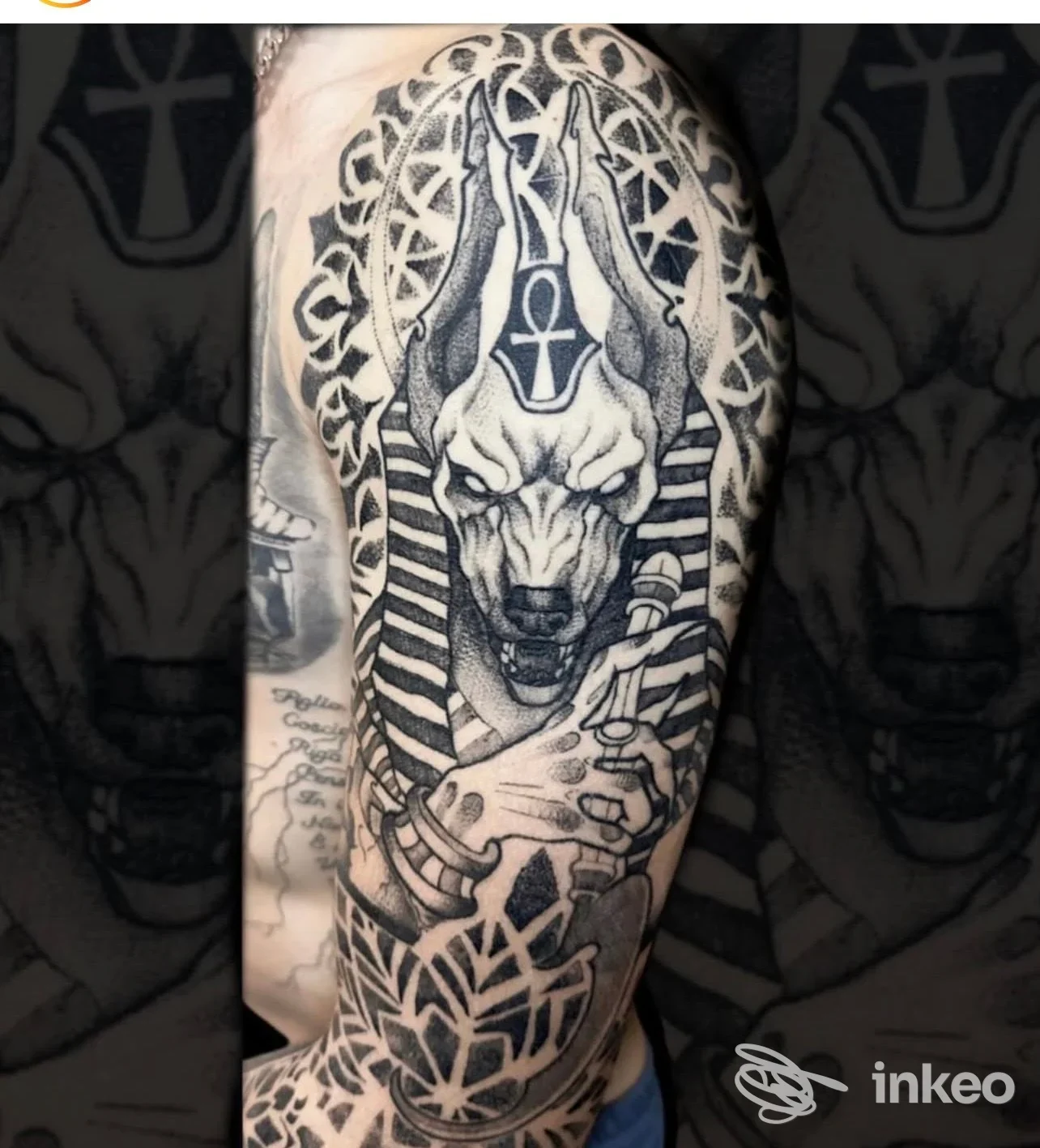 Tattoo visibile sul braccio mostra un animale alto con orecchie, zanne e decorazioni circolari, eseguito in stile blackwork.