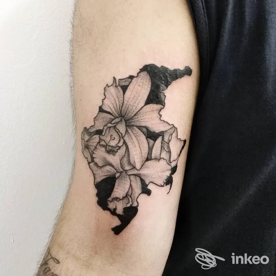 Tattoo in bianco e nero di fiori su braccio, sul lato interno del braccio, con linee nette e sfumature. Studio non indicato.