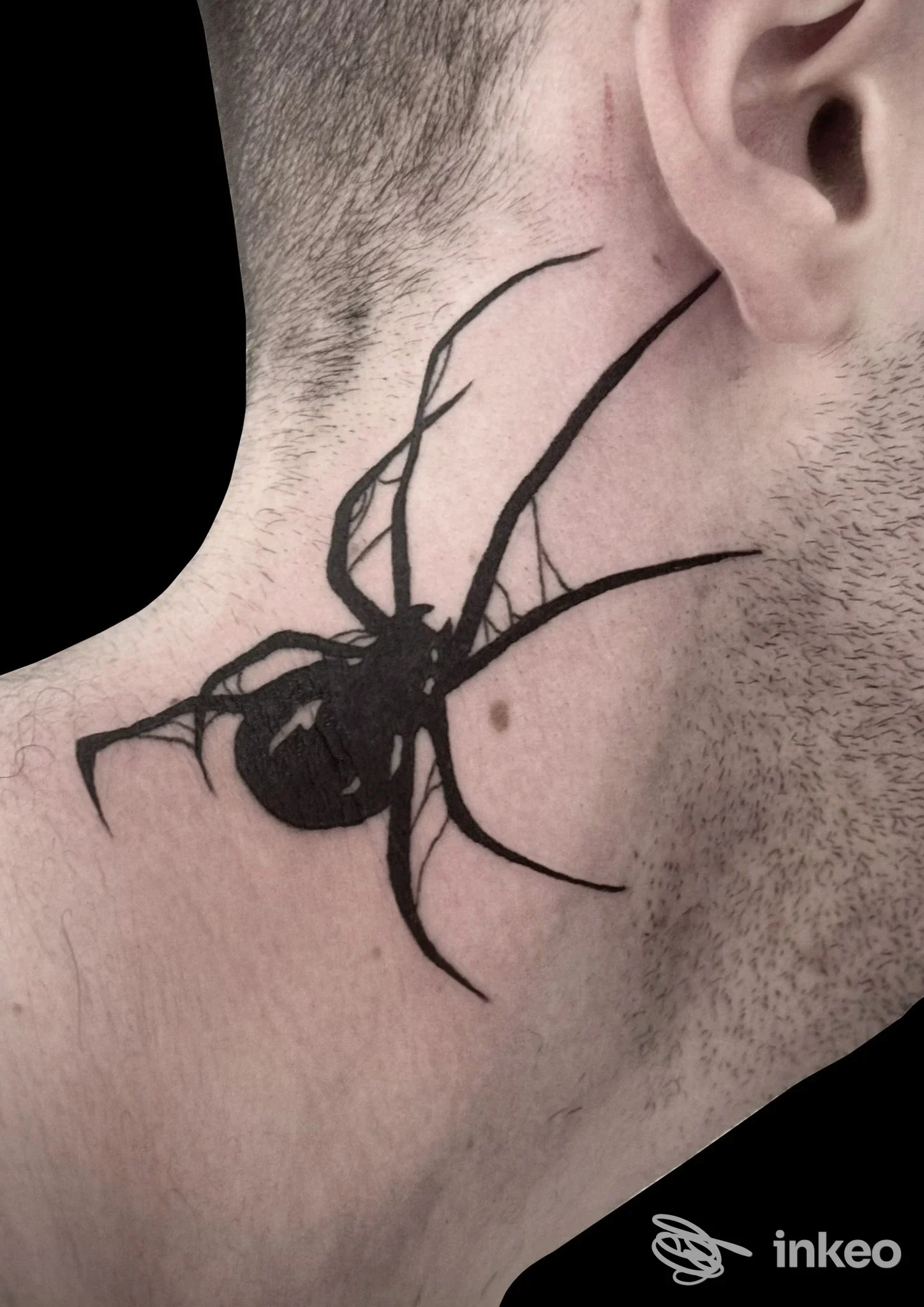 Collo laterale con tatuaggio nero a ragno stilizzato, visibile parte dell’orecchio; primo piano sull’opera corporea senza volto.