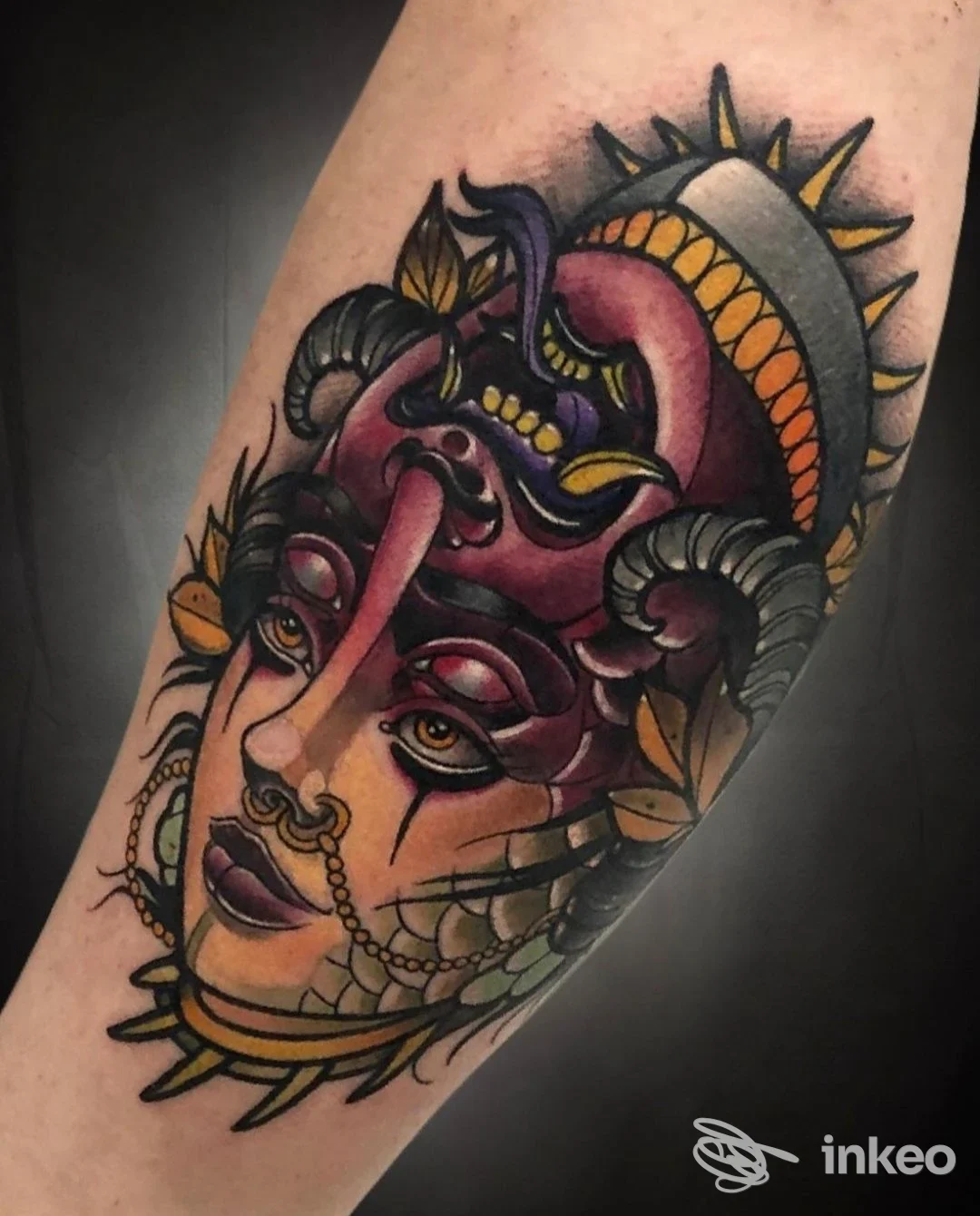 Tattoo colorato su avambraccio, raffigurante una figura femminile stilizzata con ornamenti, contorni netti e riempimenti vivaci.