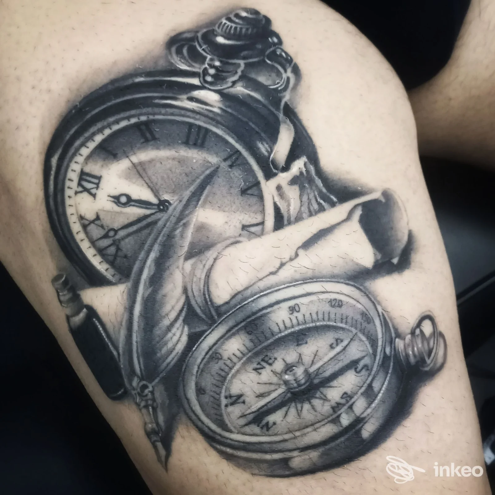 Tattoo realistico su pelle raffigurante orologi e bussola, eseguito sul braccio superiore senza volti visibili o elementi di interfaccia.