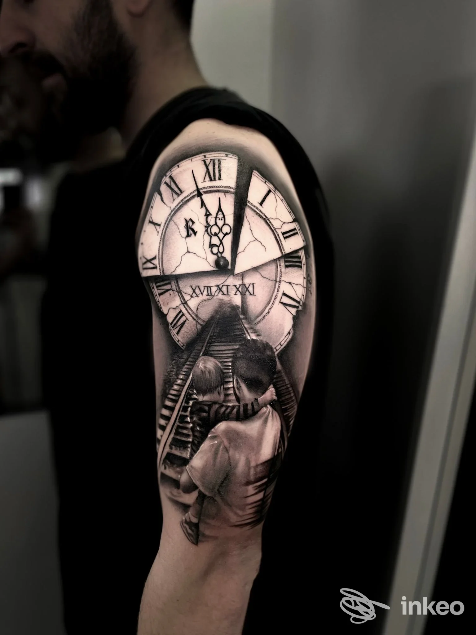 Tattoo in bianco e nero sull'avambraccio di una persona: orologio romano con lancette e scena di scale, realizzato sulla pelle.