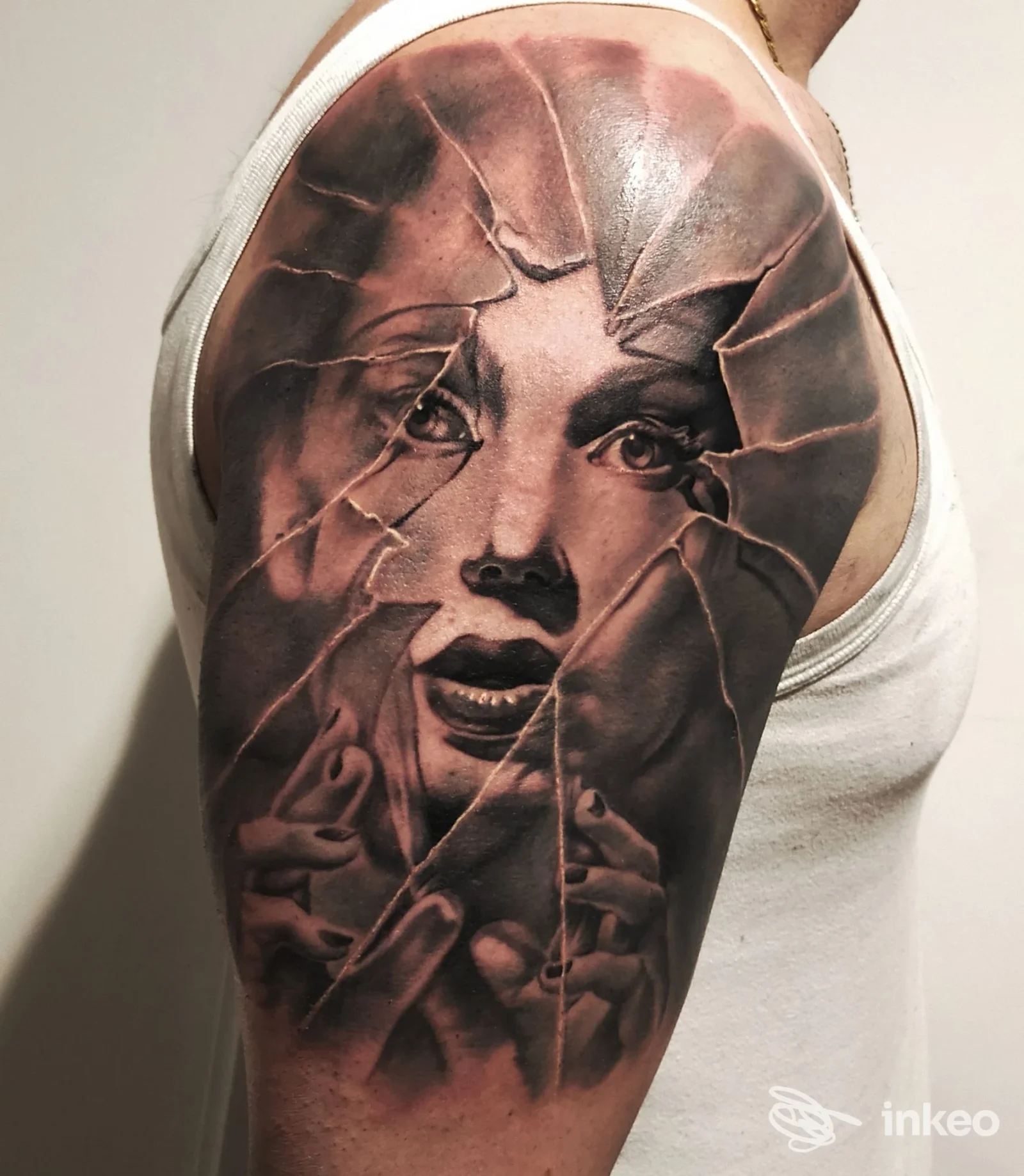 Tattoo realistico su braccio raffigurante una figura femminile in stile realistico con effetto vetro incrinato, realizzato da Arna Tattoo a Varese.