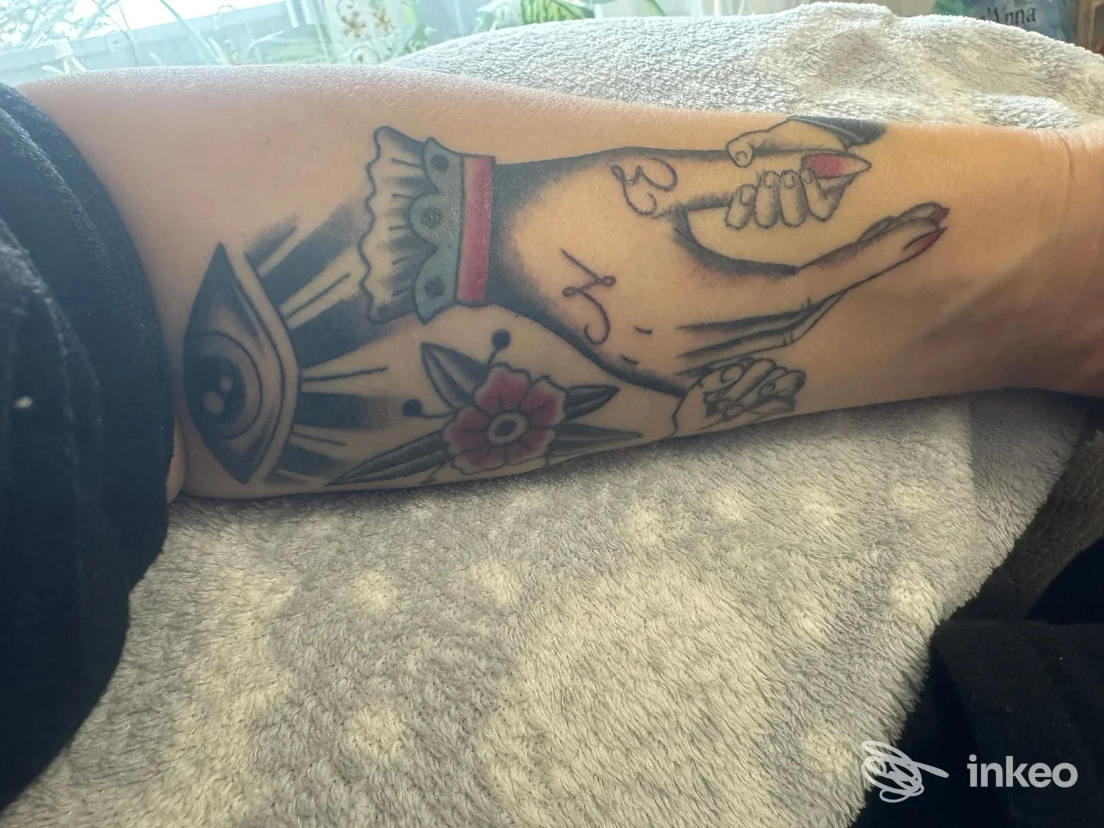Tattoo visibile sull’avambraccio, linee nette e colori limitati in stile cartoonesco, nessun volto visibile.