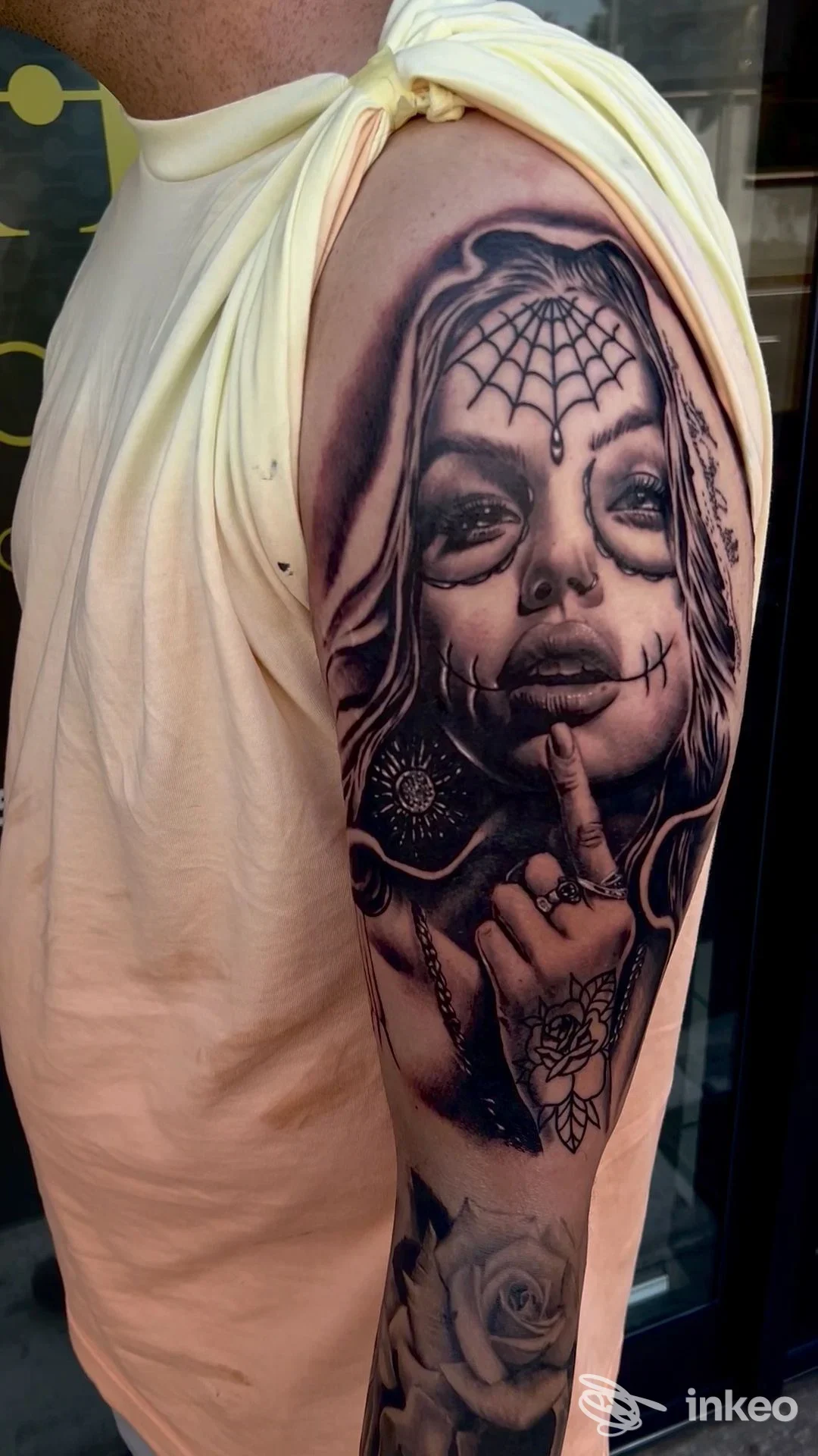 Tattoo realistico su avambraccio raffigurante una ragazza con la testa incorniciata da una ragnatela, dettagli scuri e linee definite, realizzata direttamente sulla pelle.