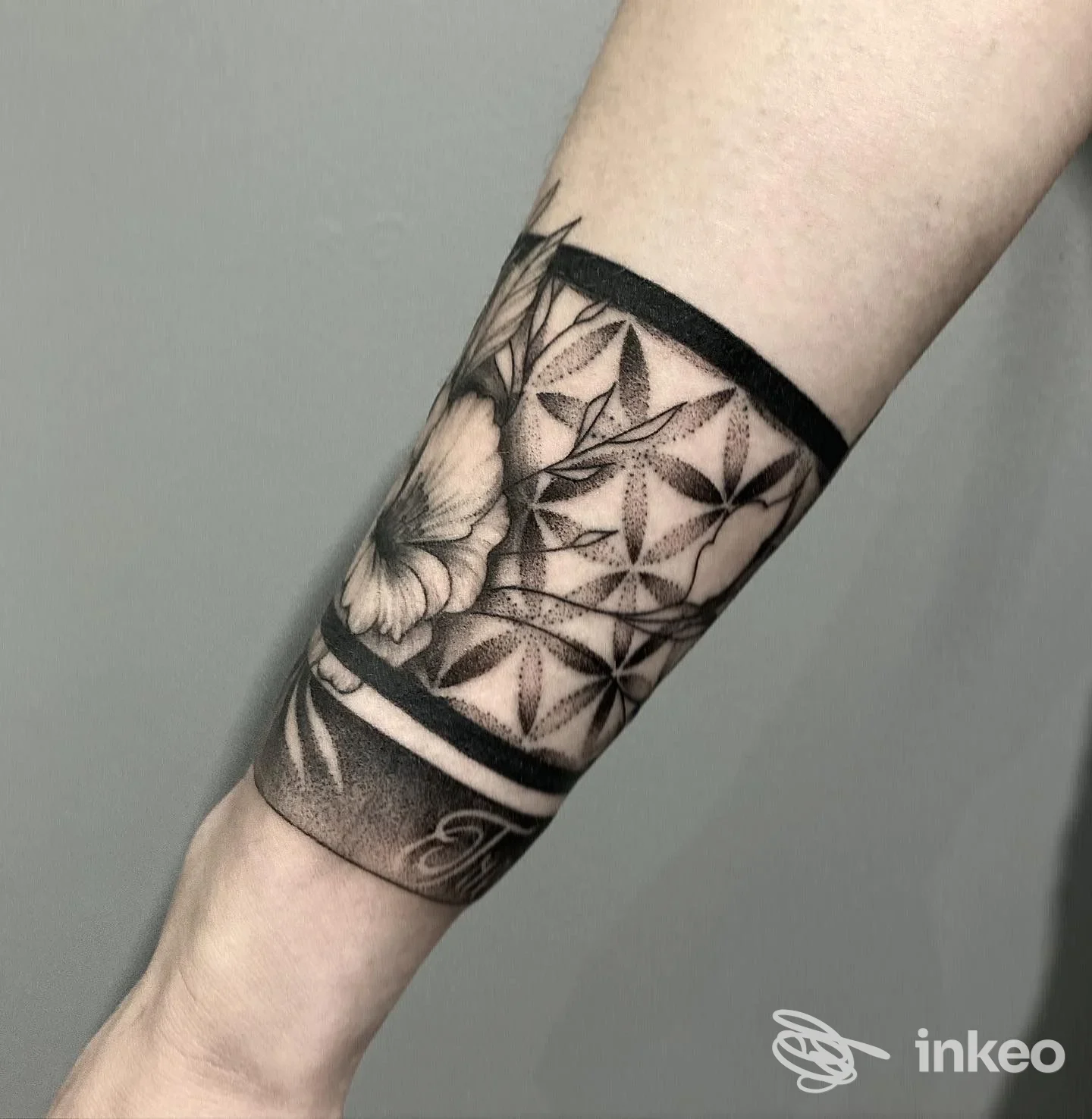Tattoo geometrico con farfalla sull'avambraccio, fascia nera continua in cornice, dettaglio di linee e puntinature nere.